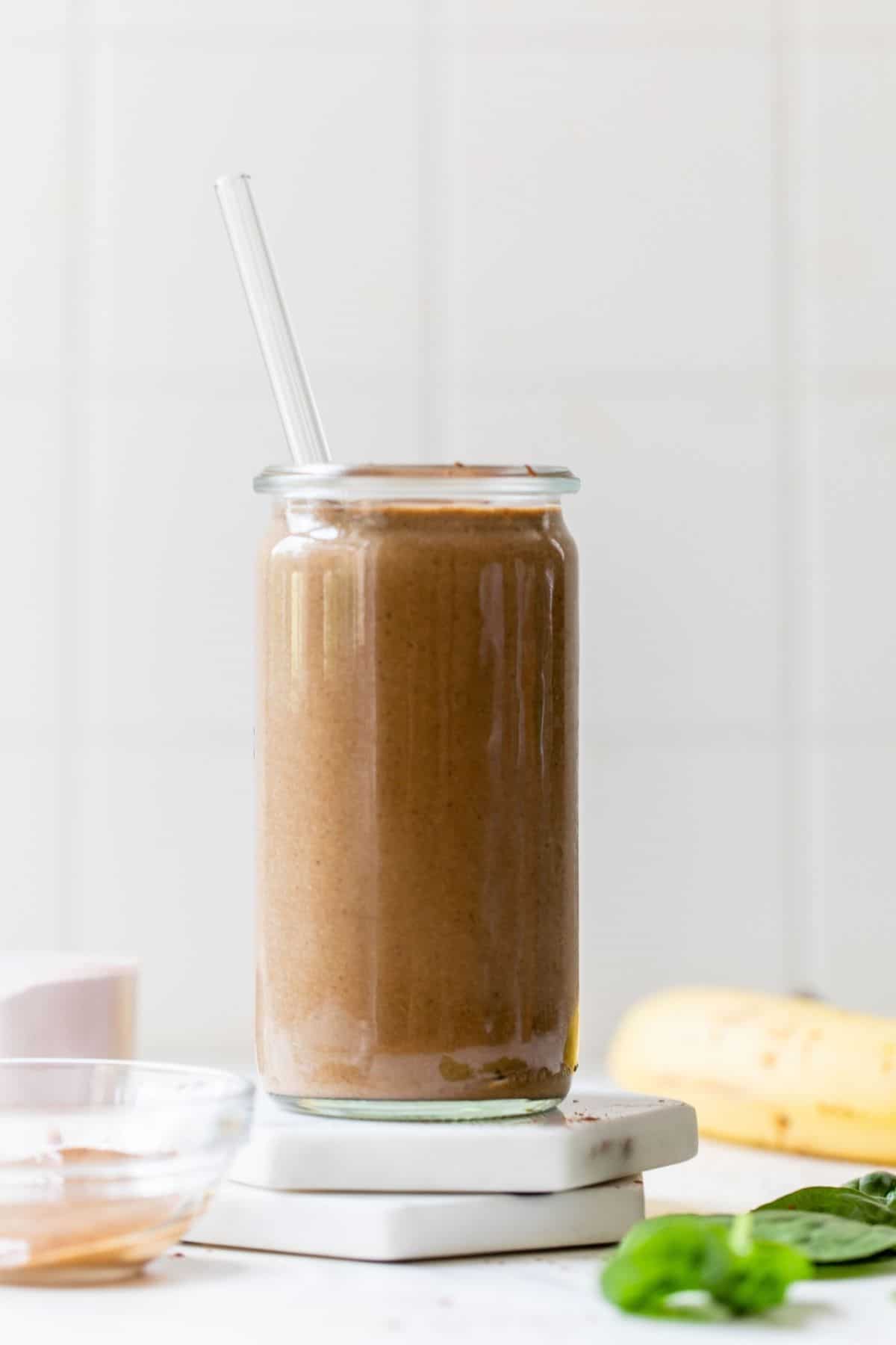 chocolate smoothie in a glass with a straw