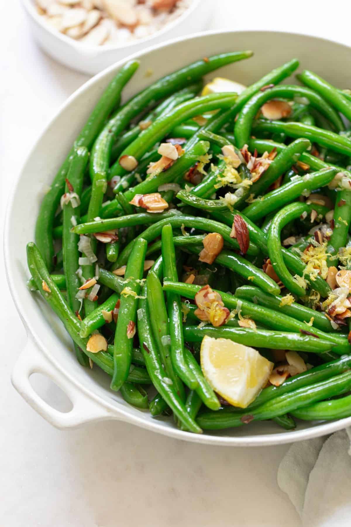 green beans topped with almonds and lemon wedges