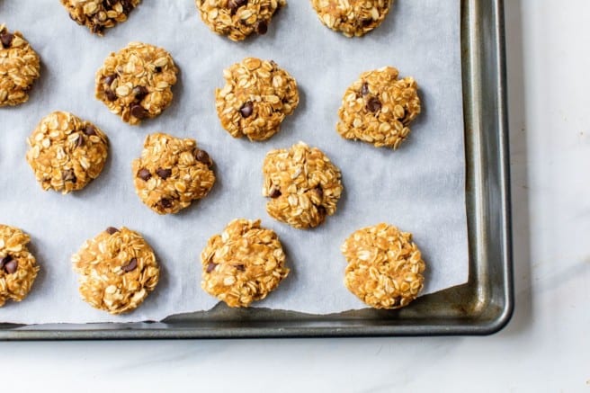 peanut butter oatmeal cookies on a parchment lined baking sheet