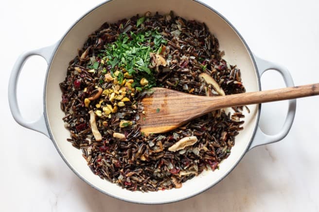 mixing wild rice with pistachios and fresh parsley