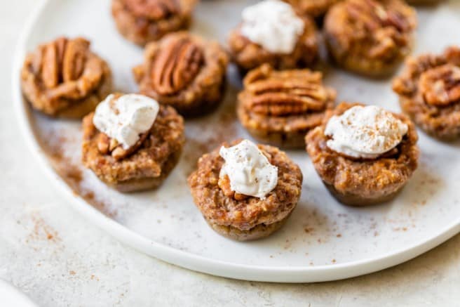 mini pecan pies on a plate topped with whipped topping