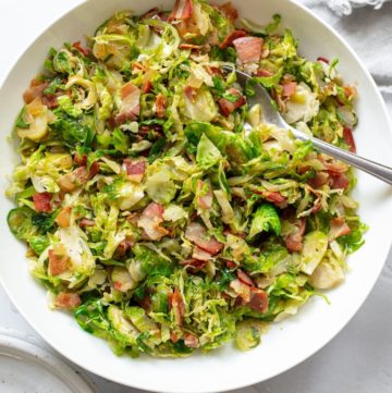 sautéed Brussels sprouts with pancetta in a white serving bowl