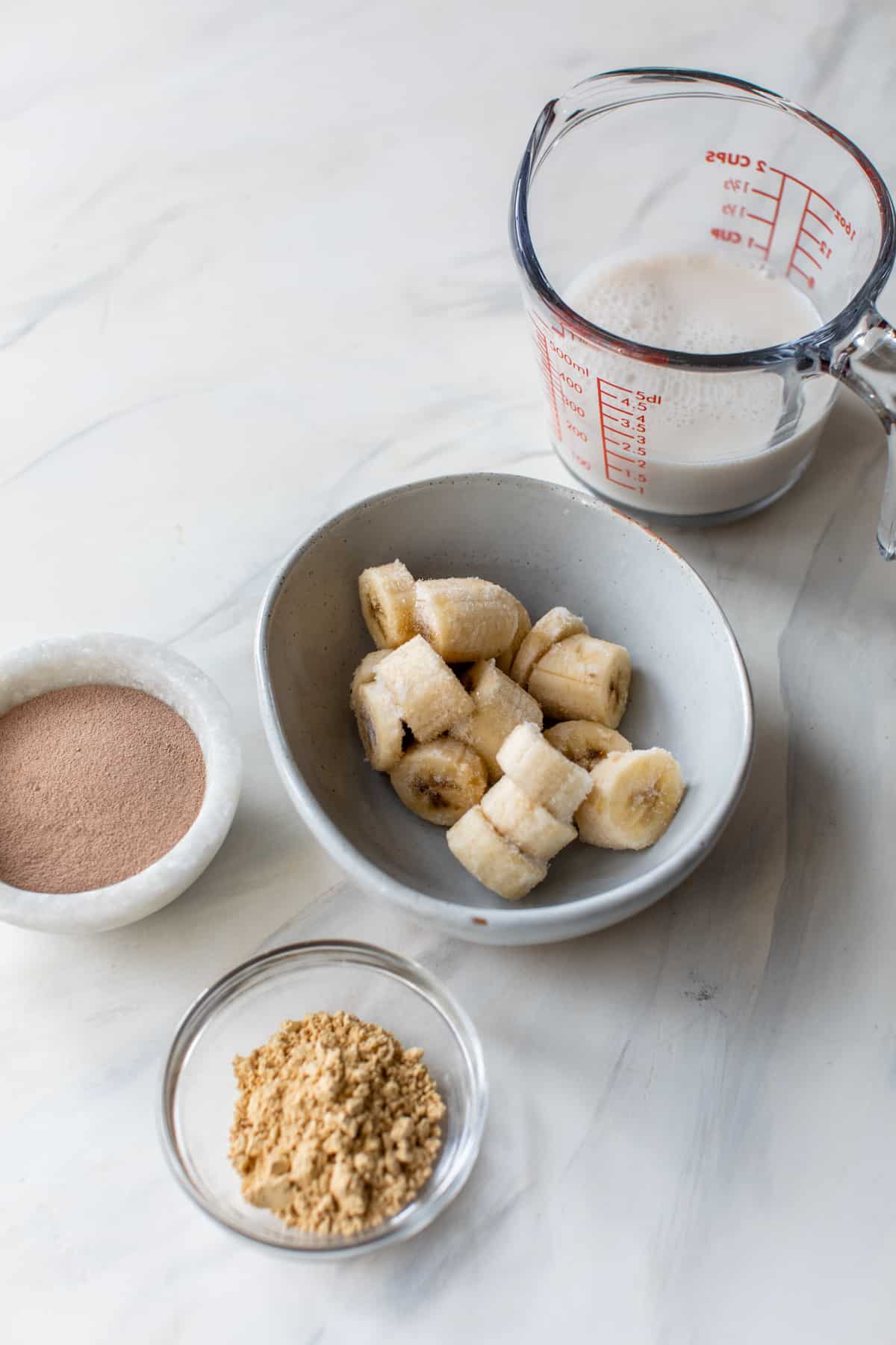 frozen bananas, chocolate protein powder, pbfit powder and milk