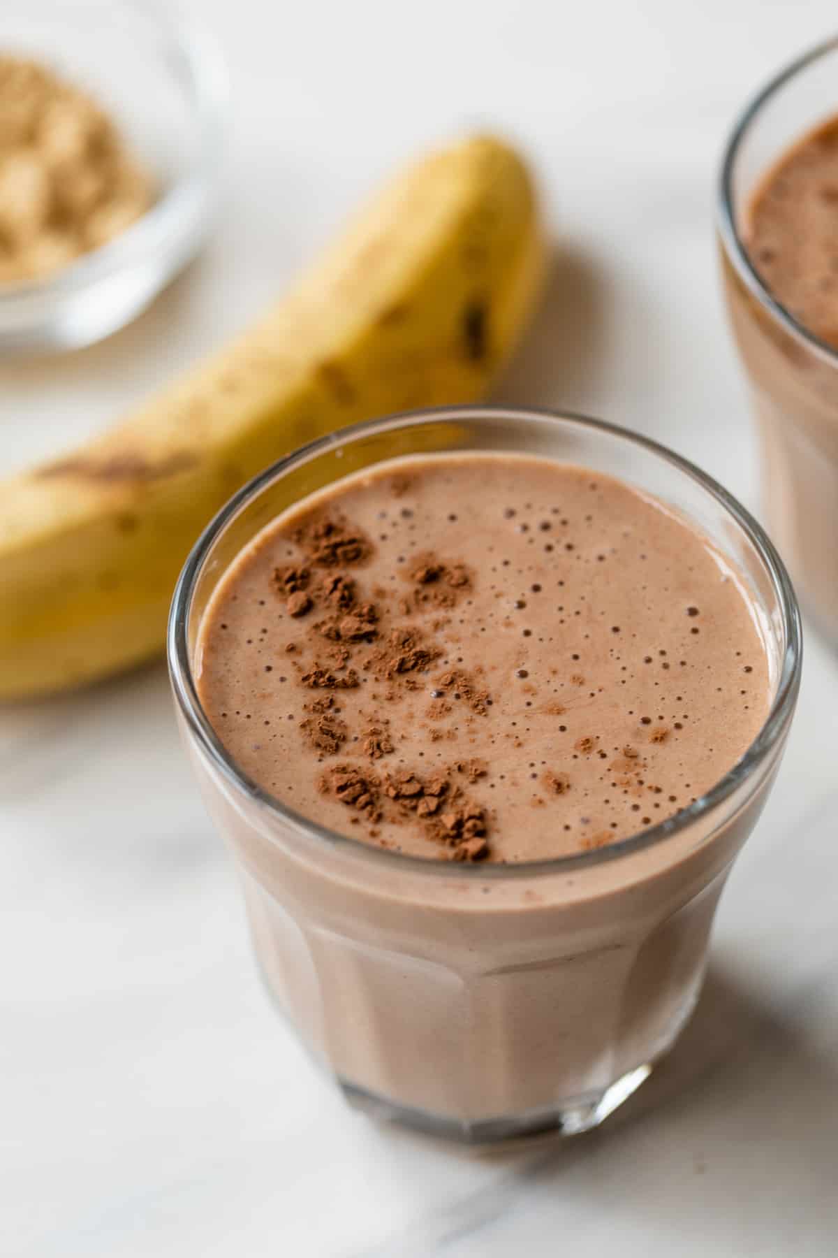 banana peanut butter chocolate protein shake in a short glass