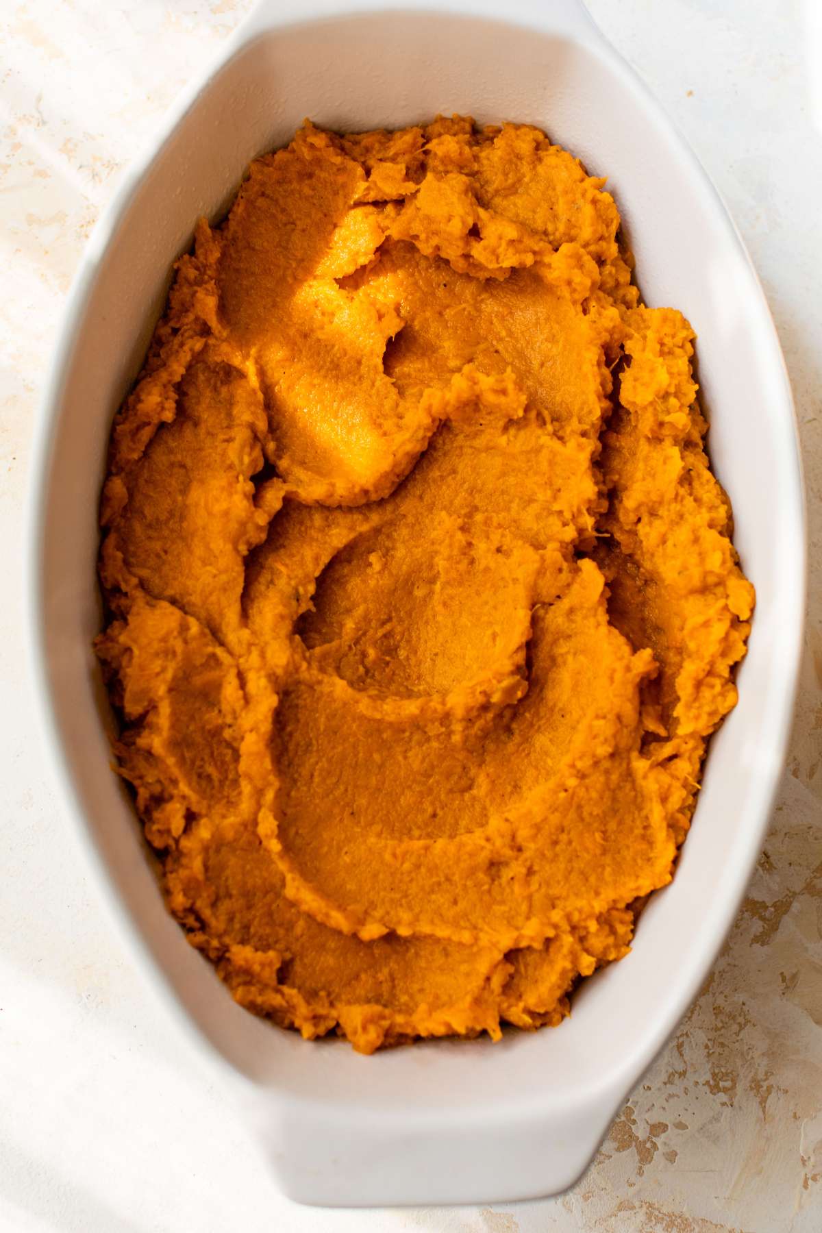 Sweet potato mixture smoothed in a casserole dish.