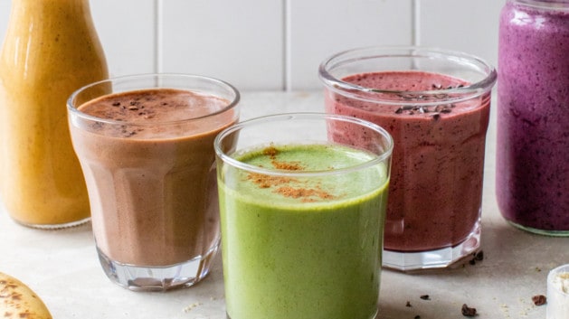 5 healthy morning smoothies on a white counter