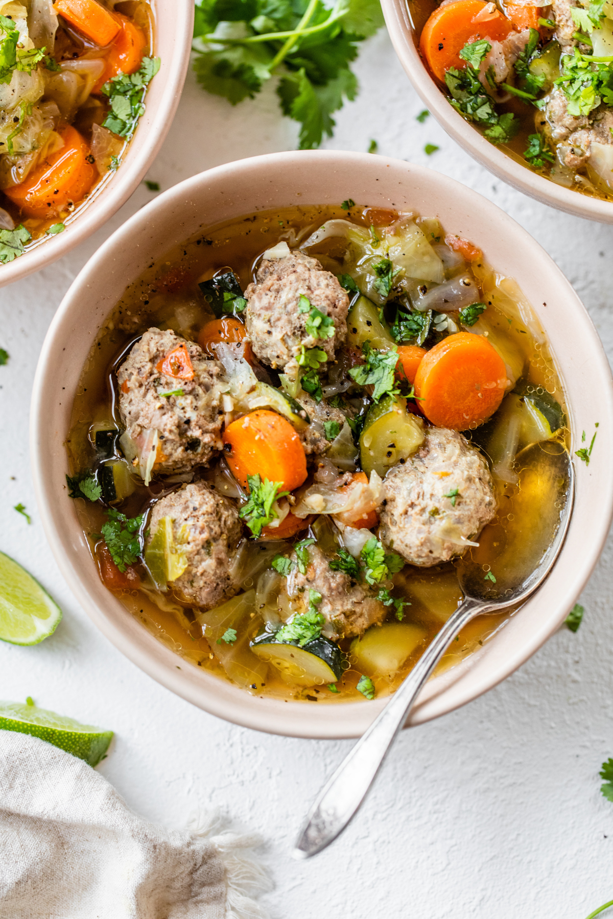 bowl of meatball and vegetable soup with cabbage, zucchini and carrots