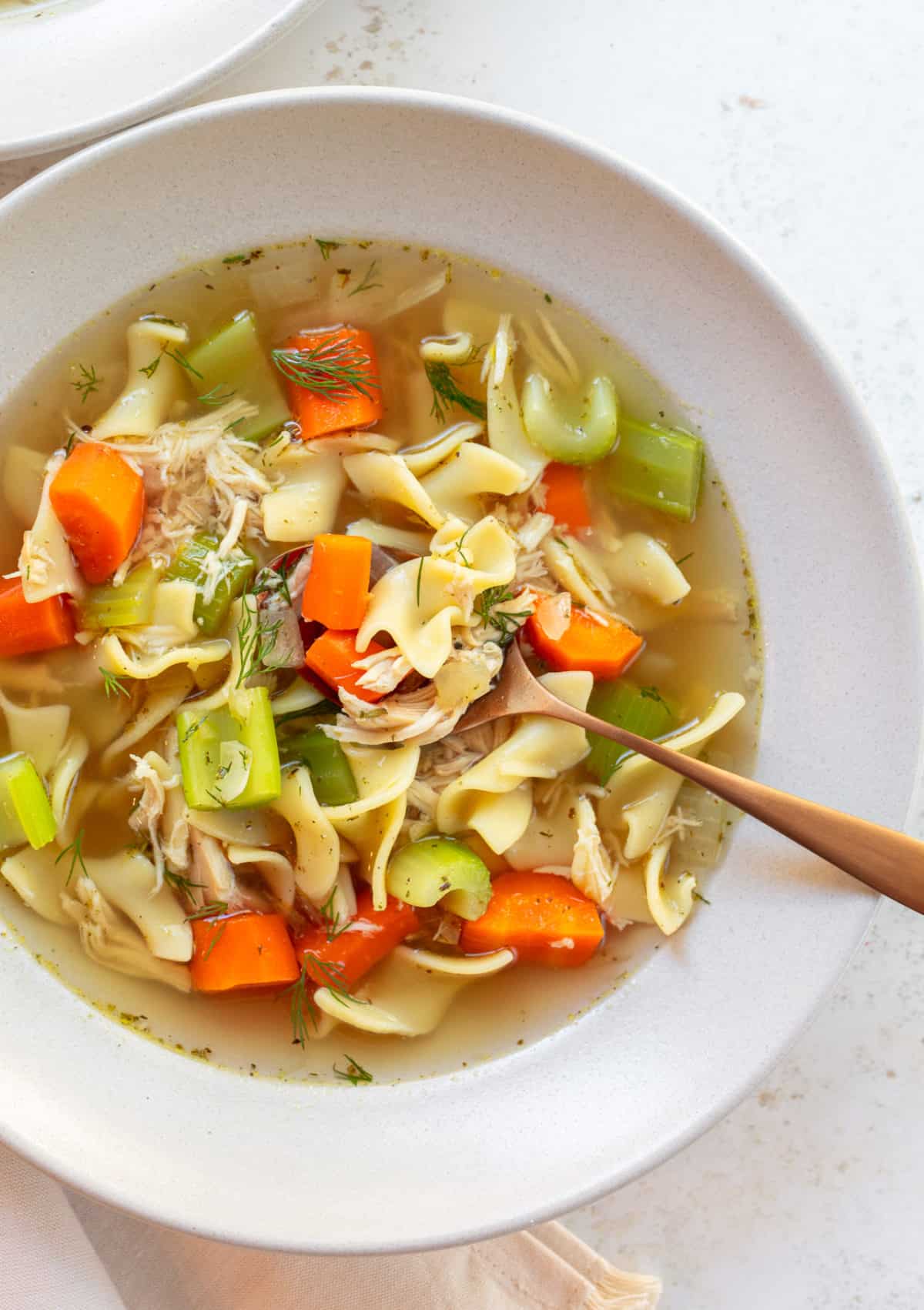 close up photo chicken noodle soup with egg noodles