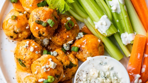 buffalo meatballs on white plate with carrots, celery and blue cheese dressing