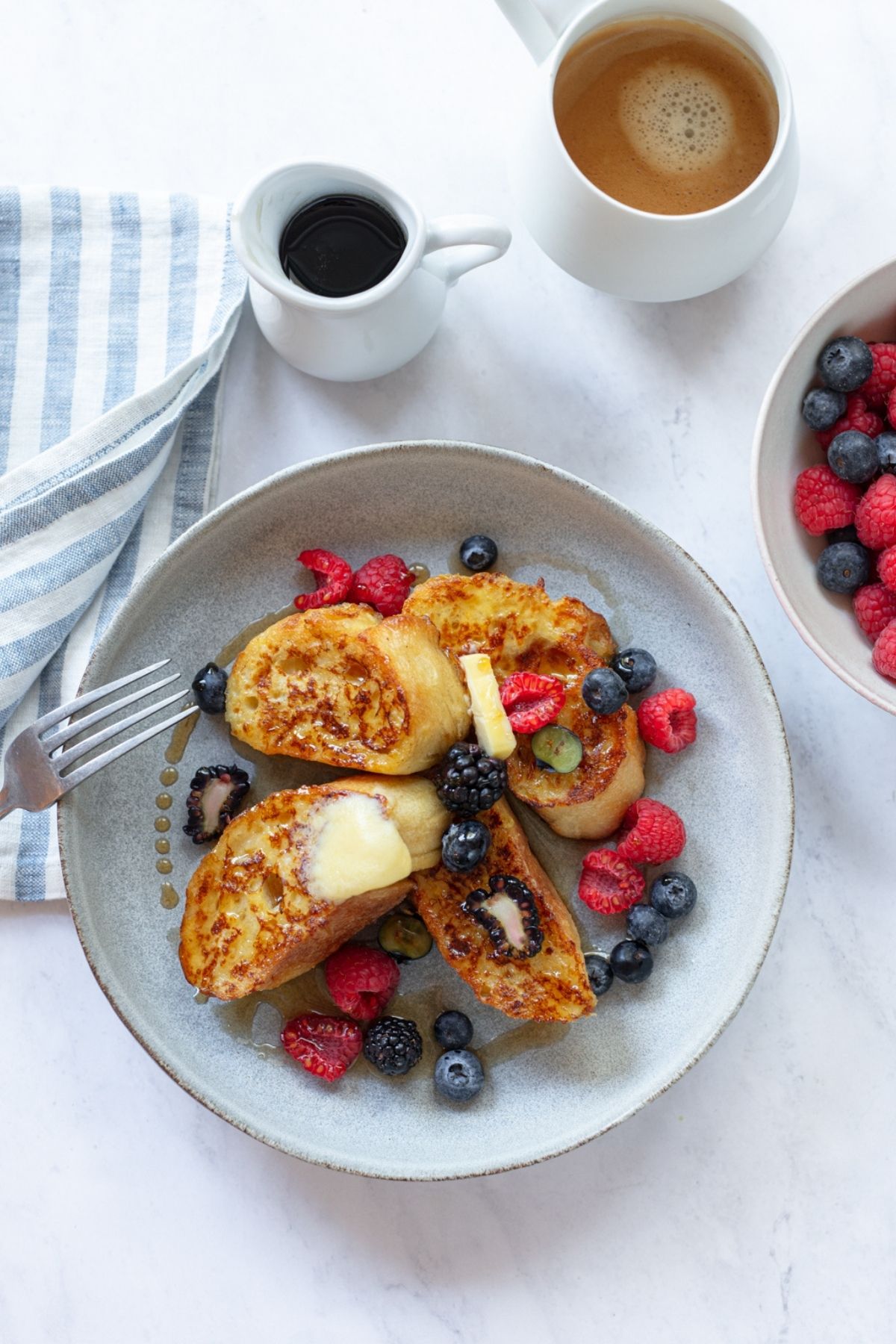 French toast served with berries, butter and coffee.