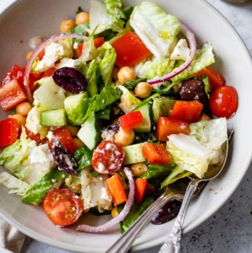 Salad with red bell pepper, olives and chickpeas in a bowl.