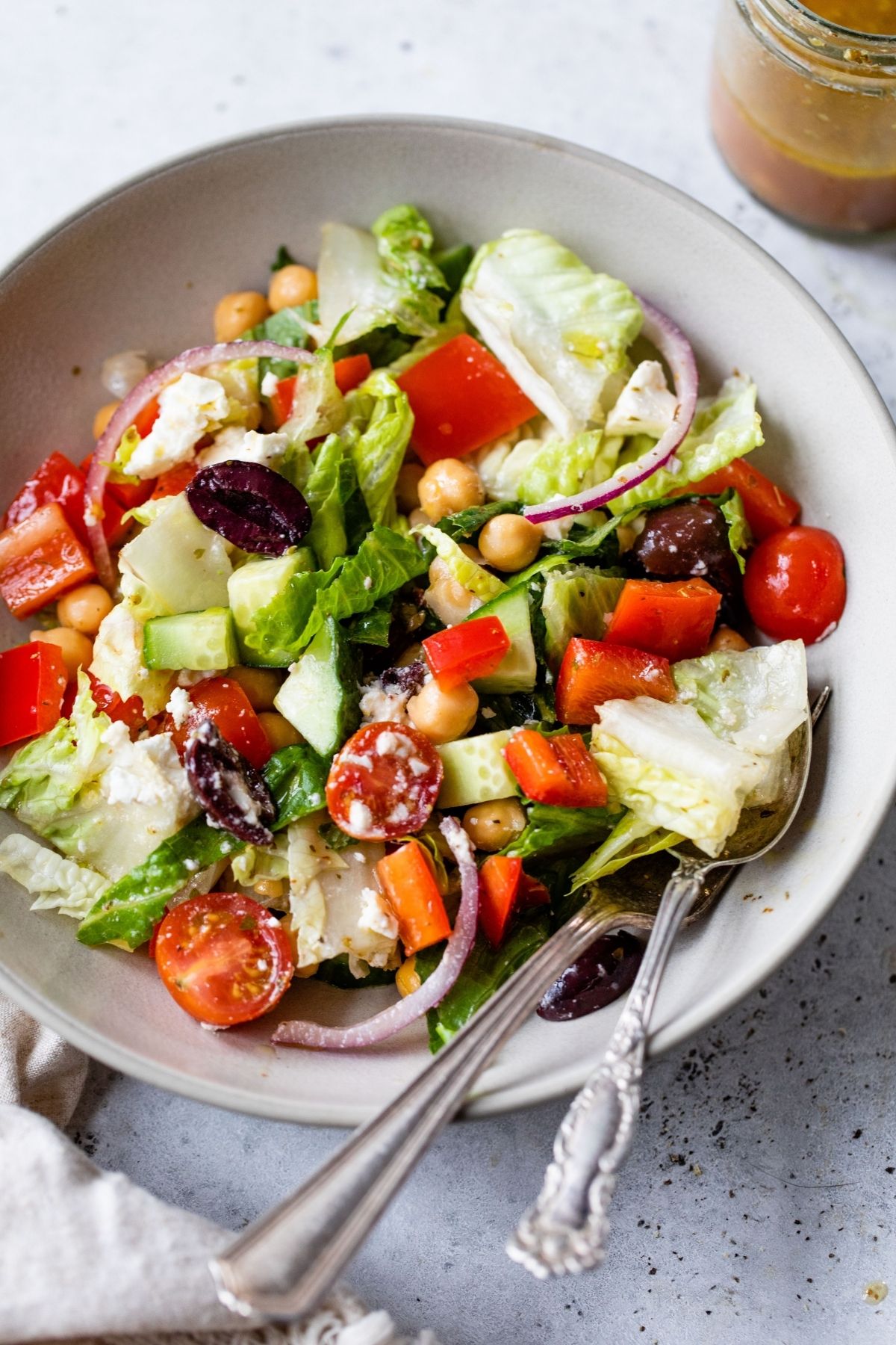 Salad with red bell pepper, olives and chickpeas in a bowl.
