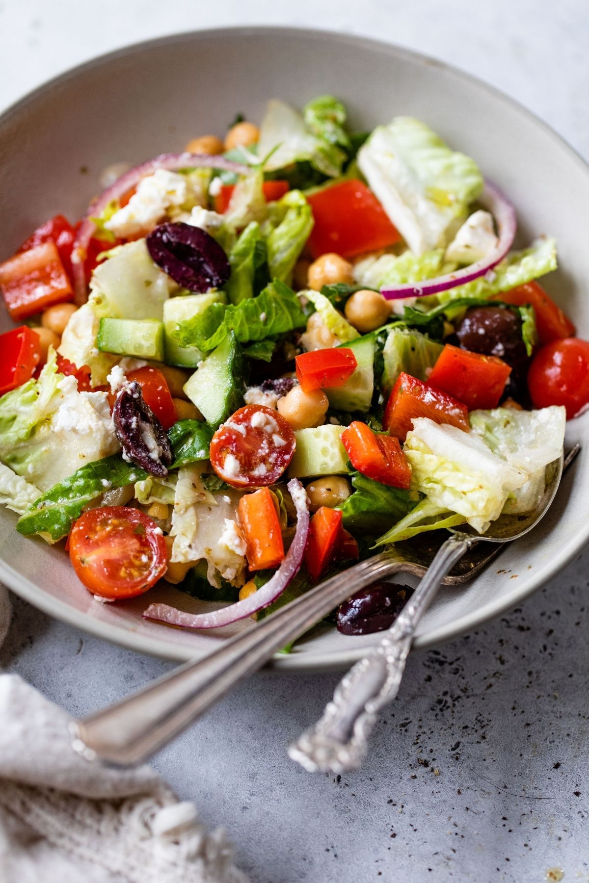 Greek Salad in a white bowl with a fork.