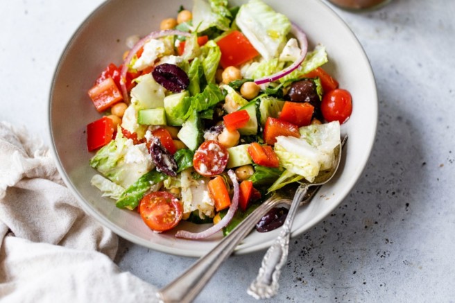 Greek salad in a white bowl.