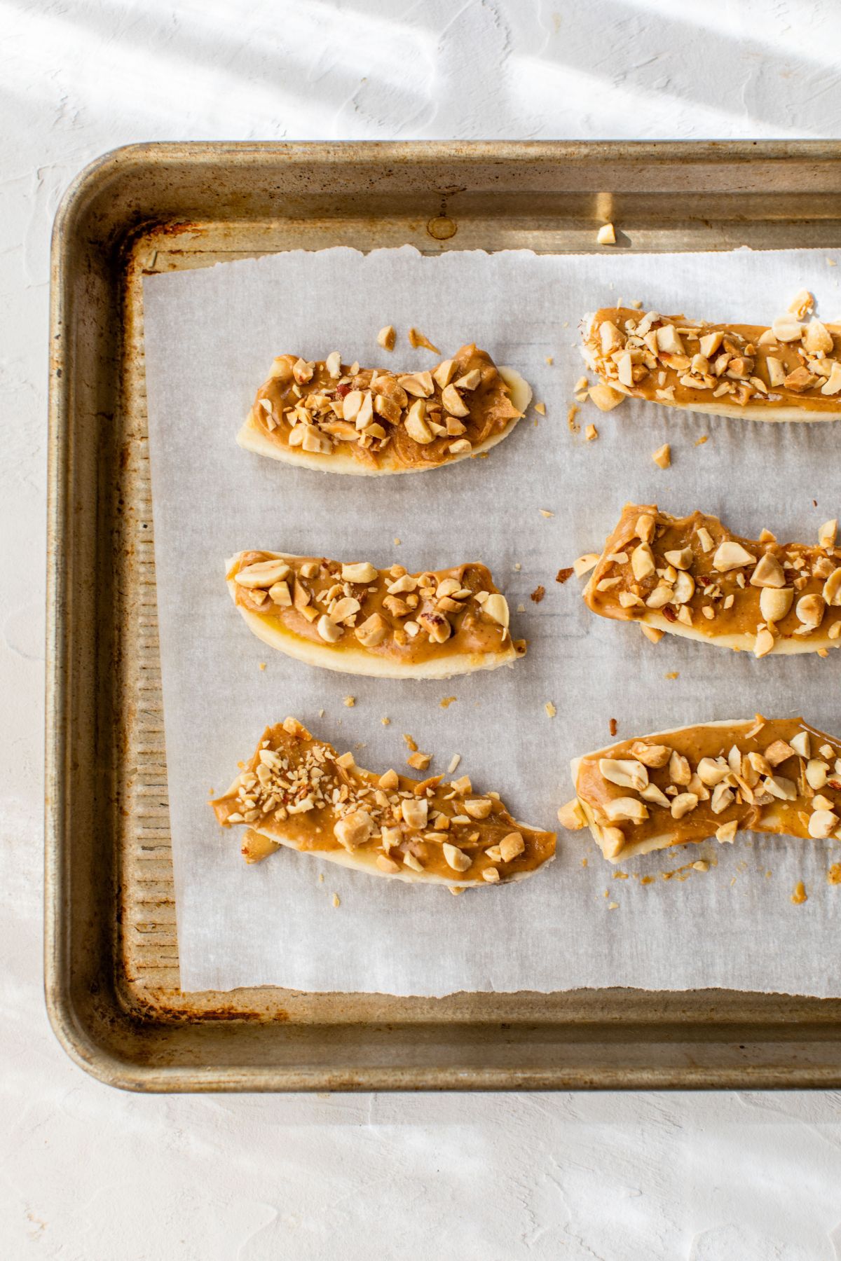 Banana slices covered with peanut butter and chopped peanuts.