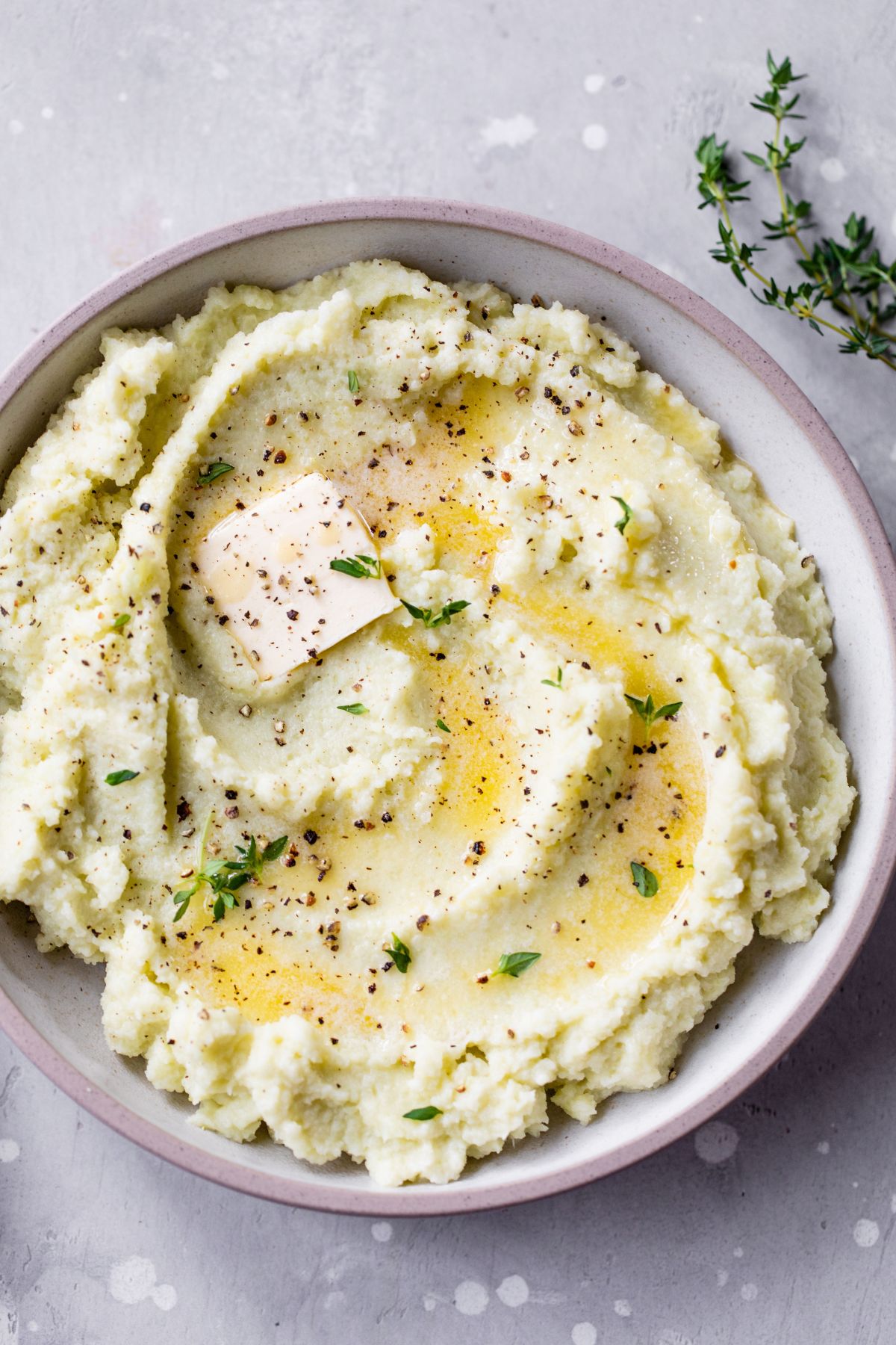 Mashed cauliflower topped with butter and fresh parsley.