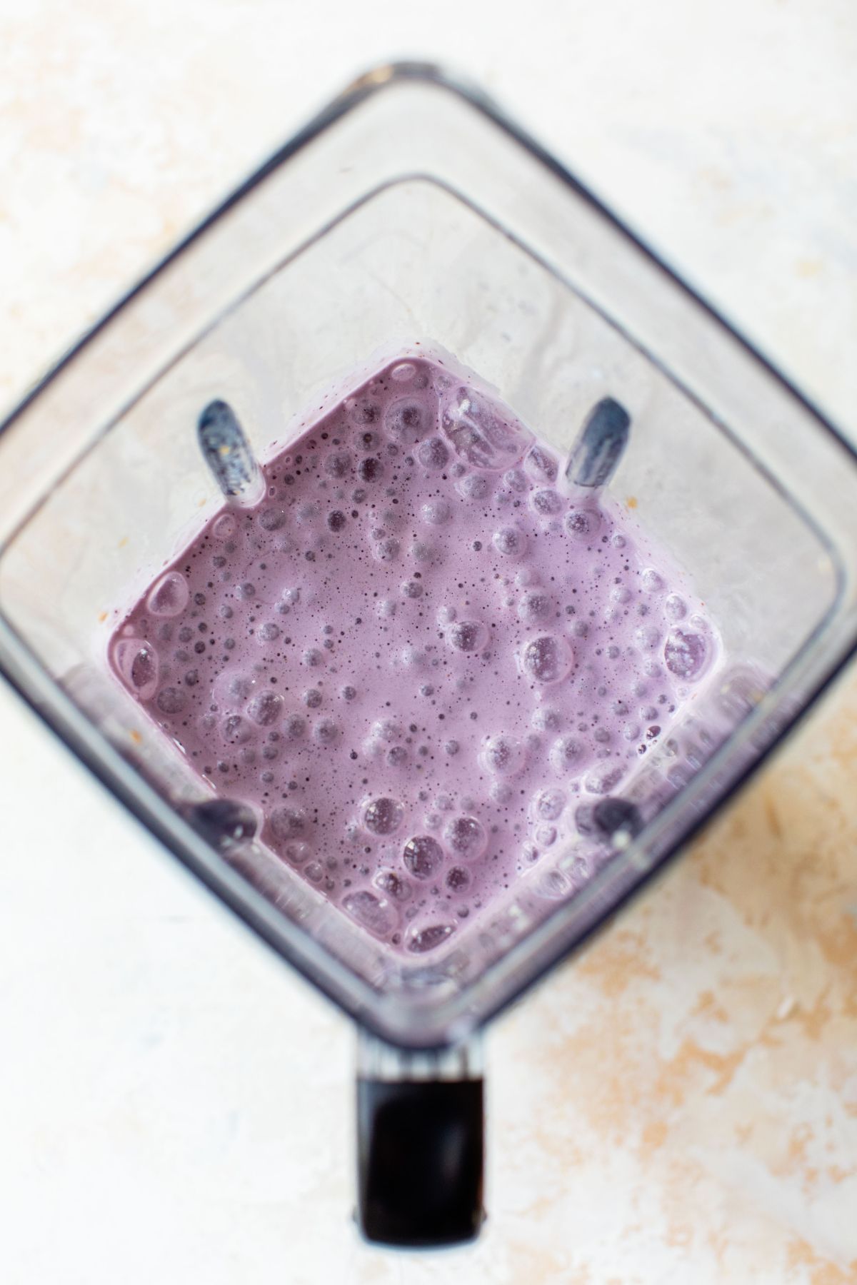 Blended blueberry smoothie in a blender.
