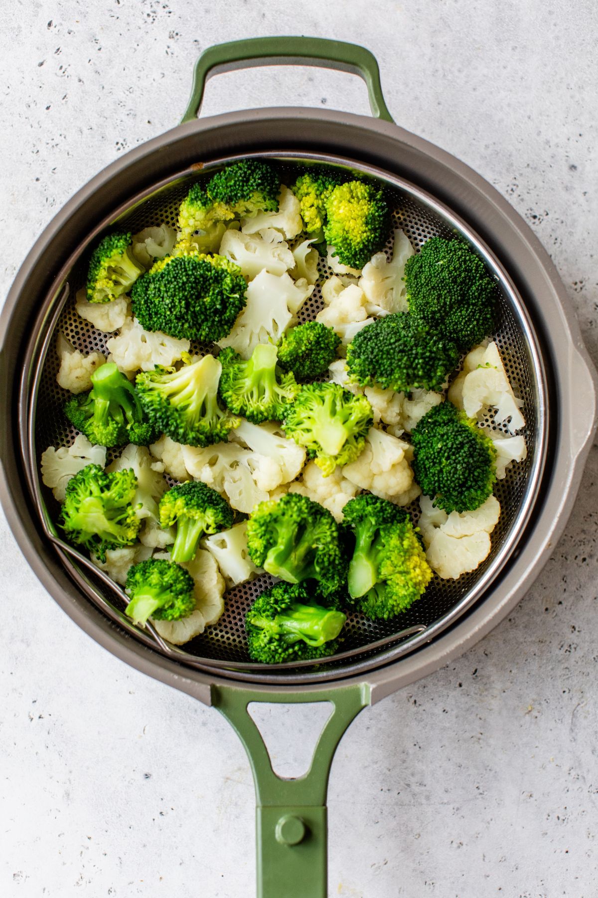 Broccoli and cauliflower in a steamer basket.