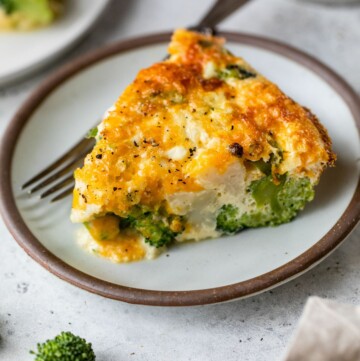 Serving of crustless quiche with broccoli on a plate.