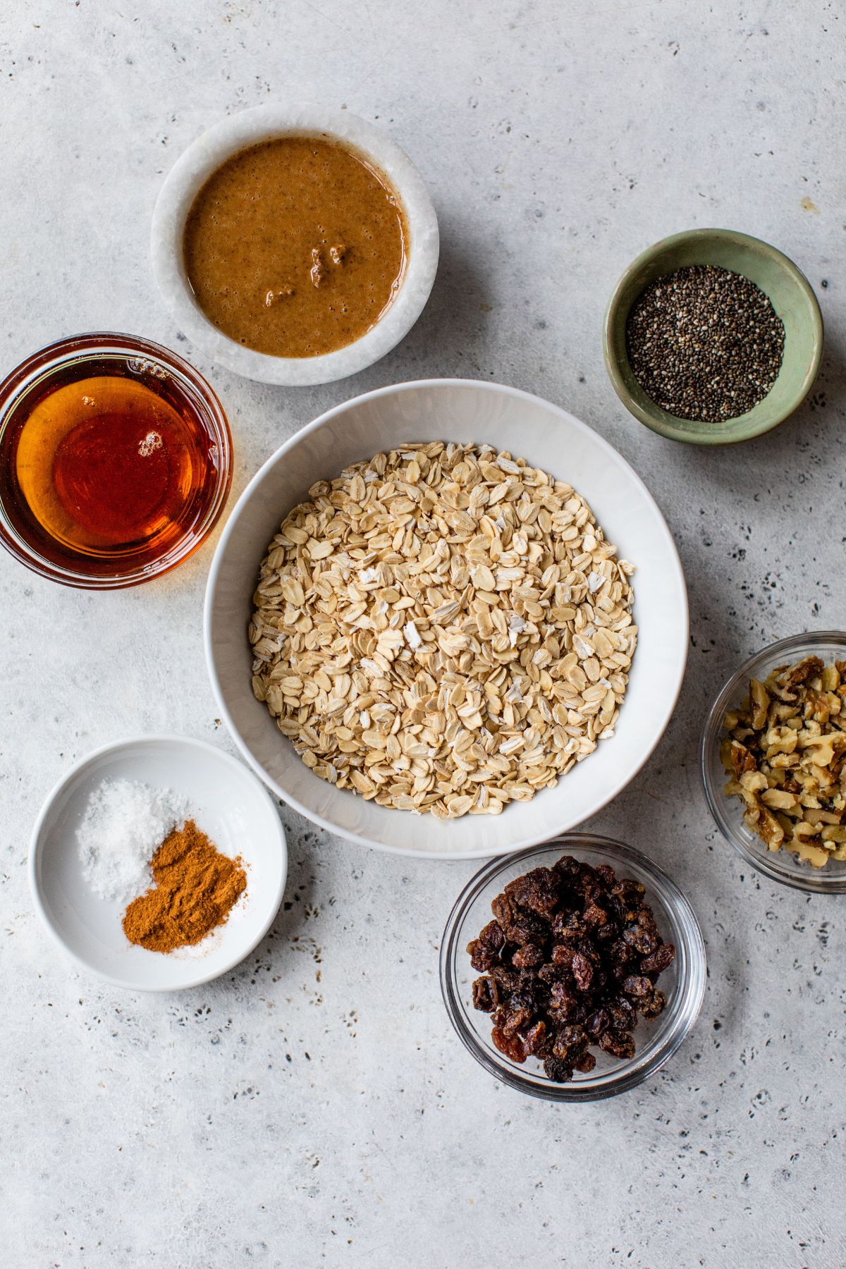 Ingredients for making oatmeal energy balls divided into small bowls.