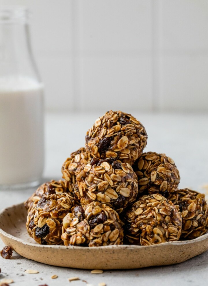 Oatmeal raisin energy bites stacked on a plate.