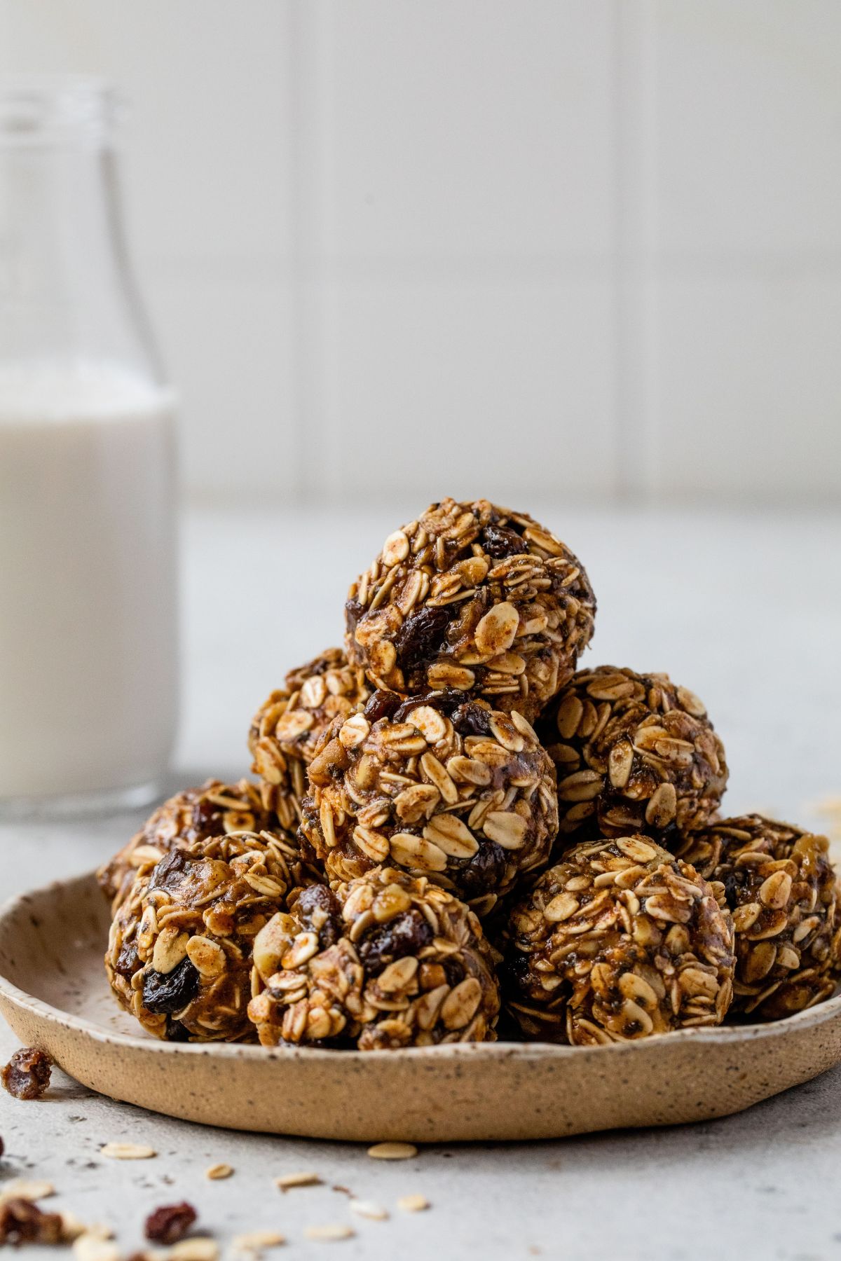 Oatmeal raisin energy bites stacked on a plate.