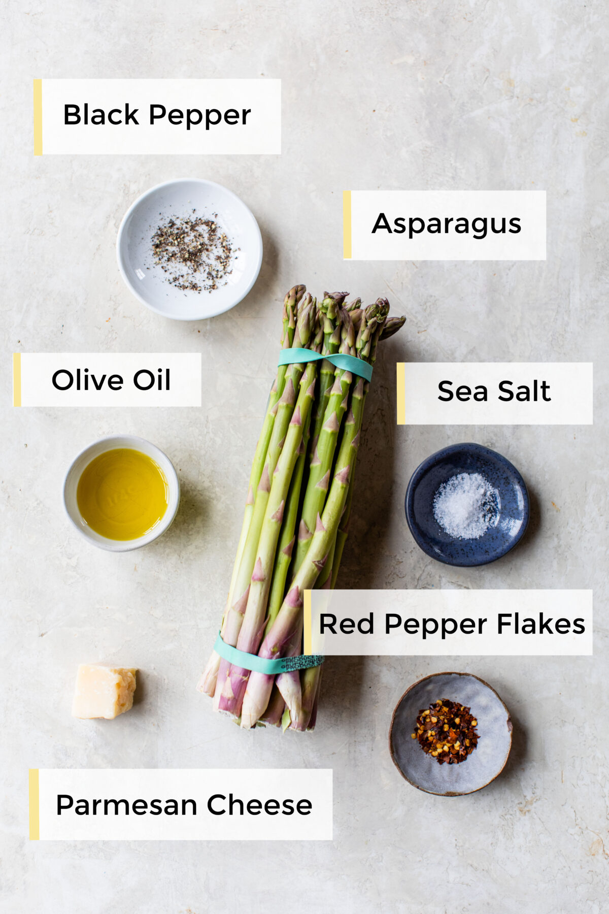 ingredients to make roasted asparagus on a white board