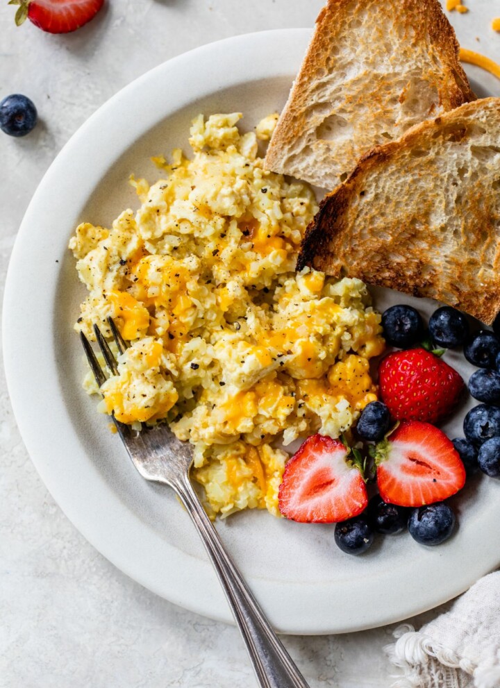 Scrambled eggs with cauliflower served with berries and toast.
