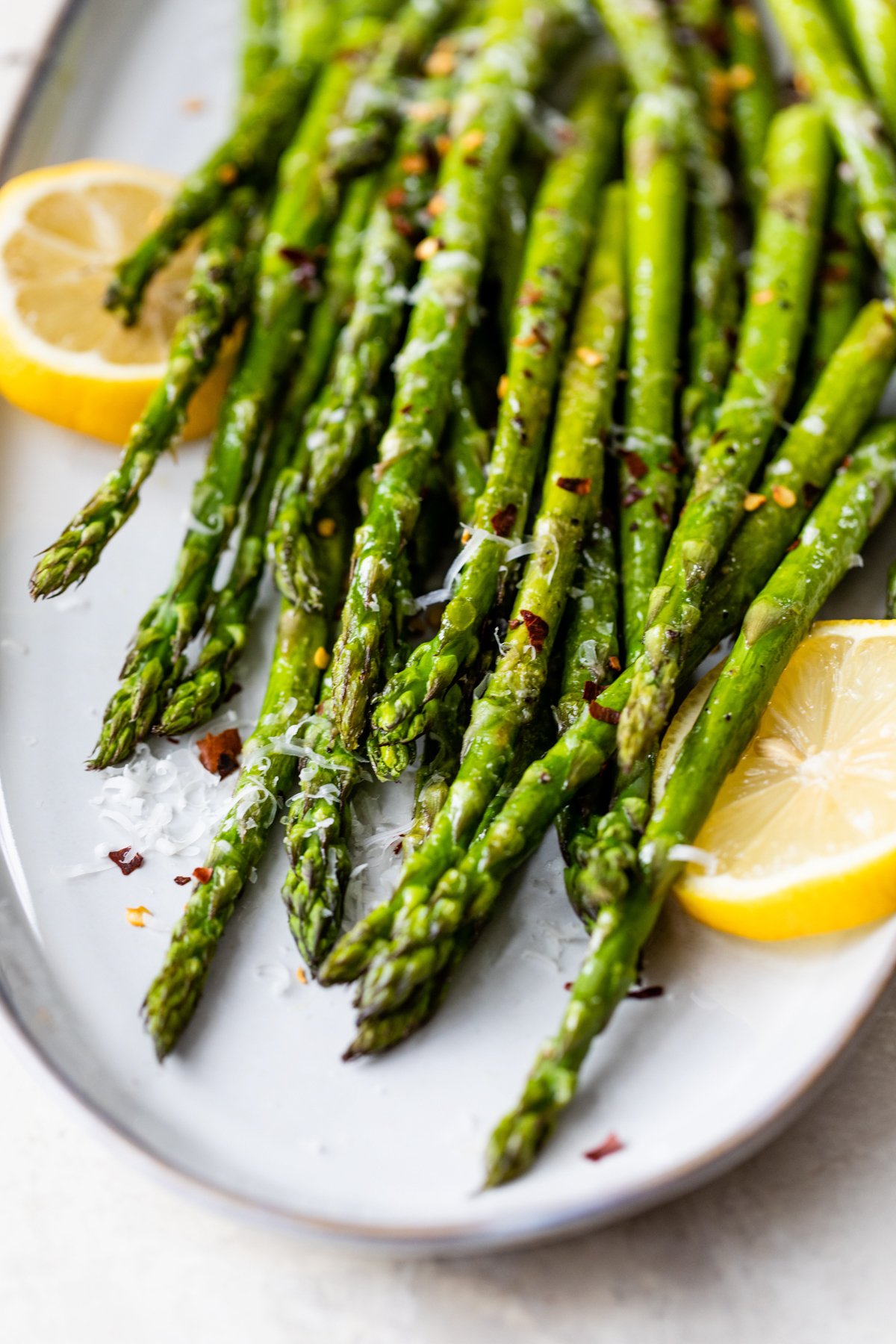 fresh roasted asparagus on a platter with lemons