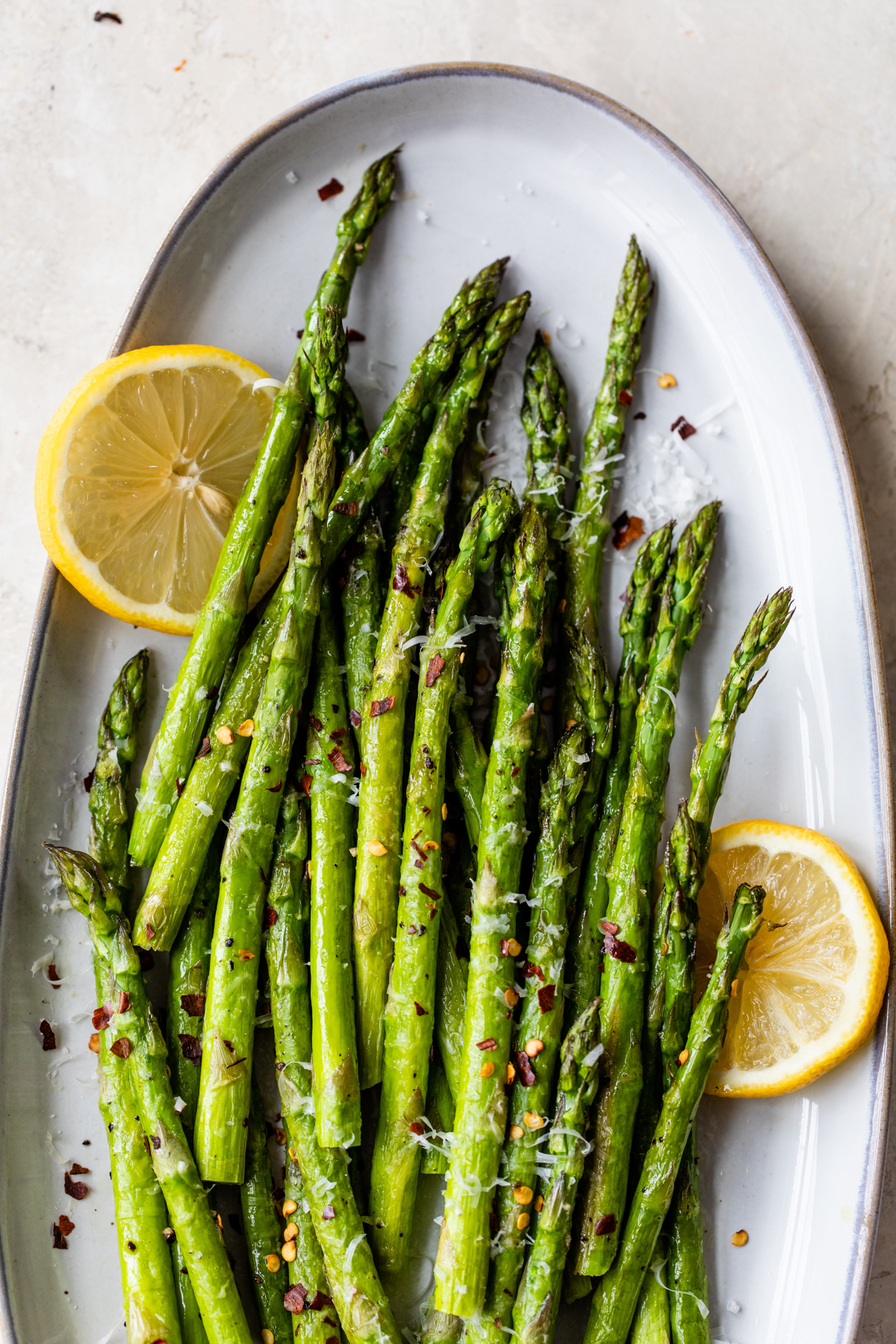 Roasted asparagus topped with Parmesan cheese and red pepper flakes - served with fresh lemon.