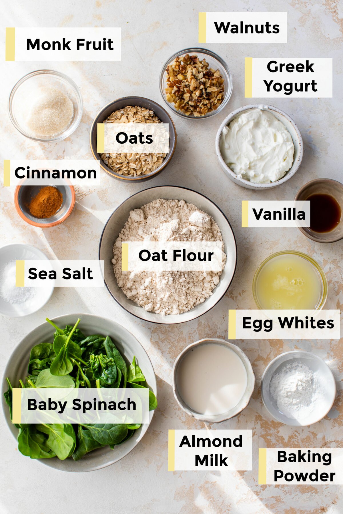 all of the ingredients for spinach oatmeal pancakes on the counter in small bowls