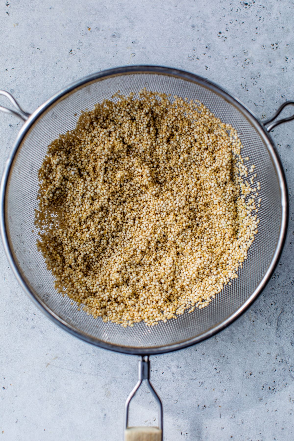 Rinsing quinoa in a mesh strainer.