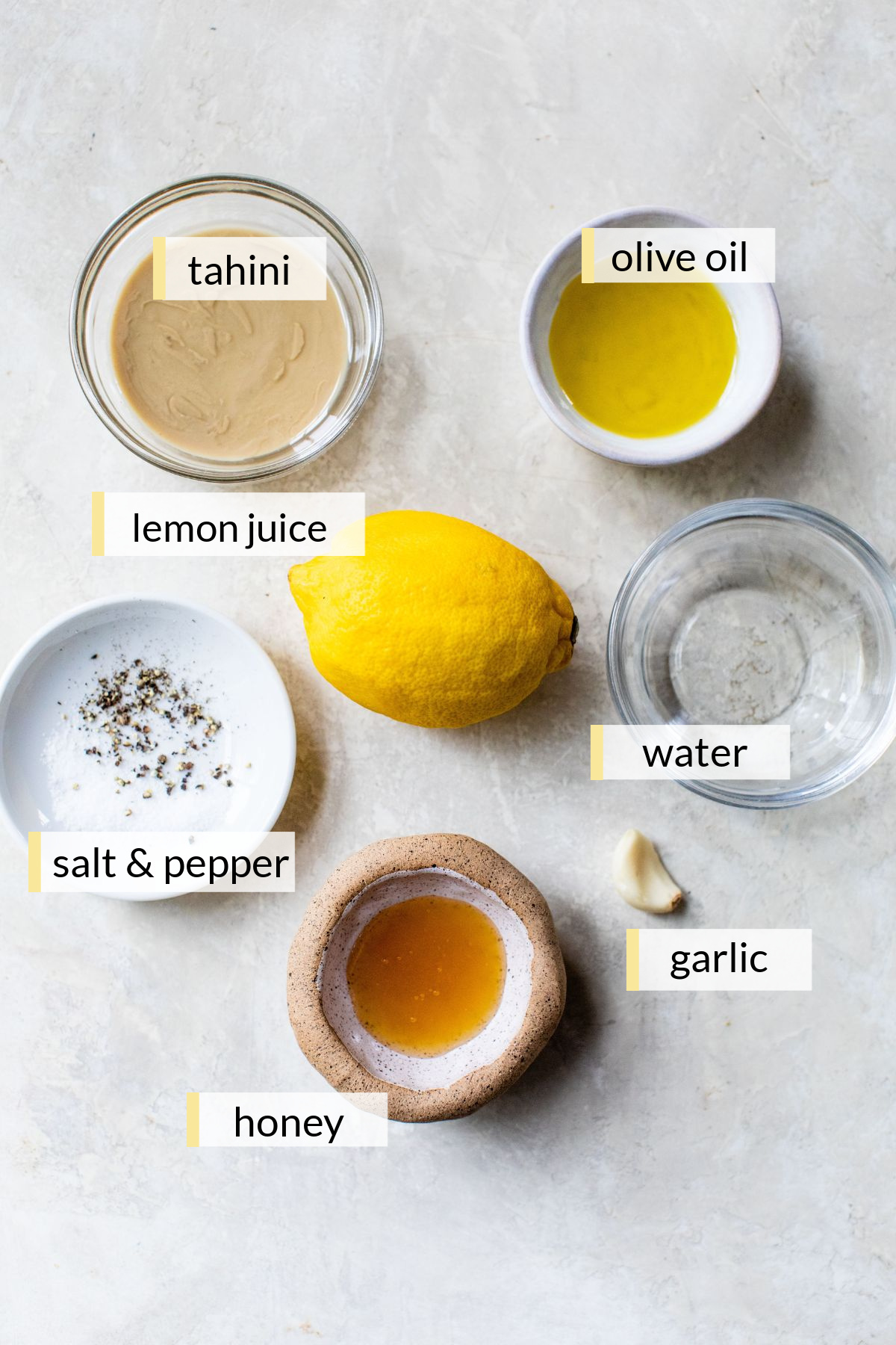 Lemon, tahini, olive oil, honey, garlic and water divided into small portions.