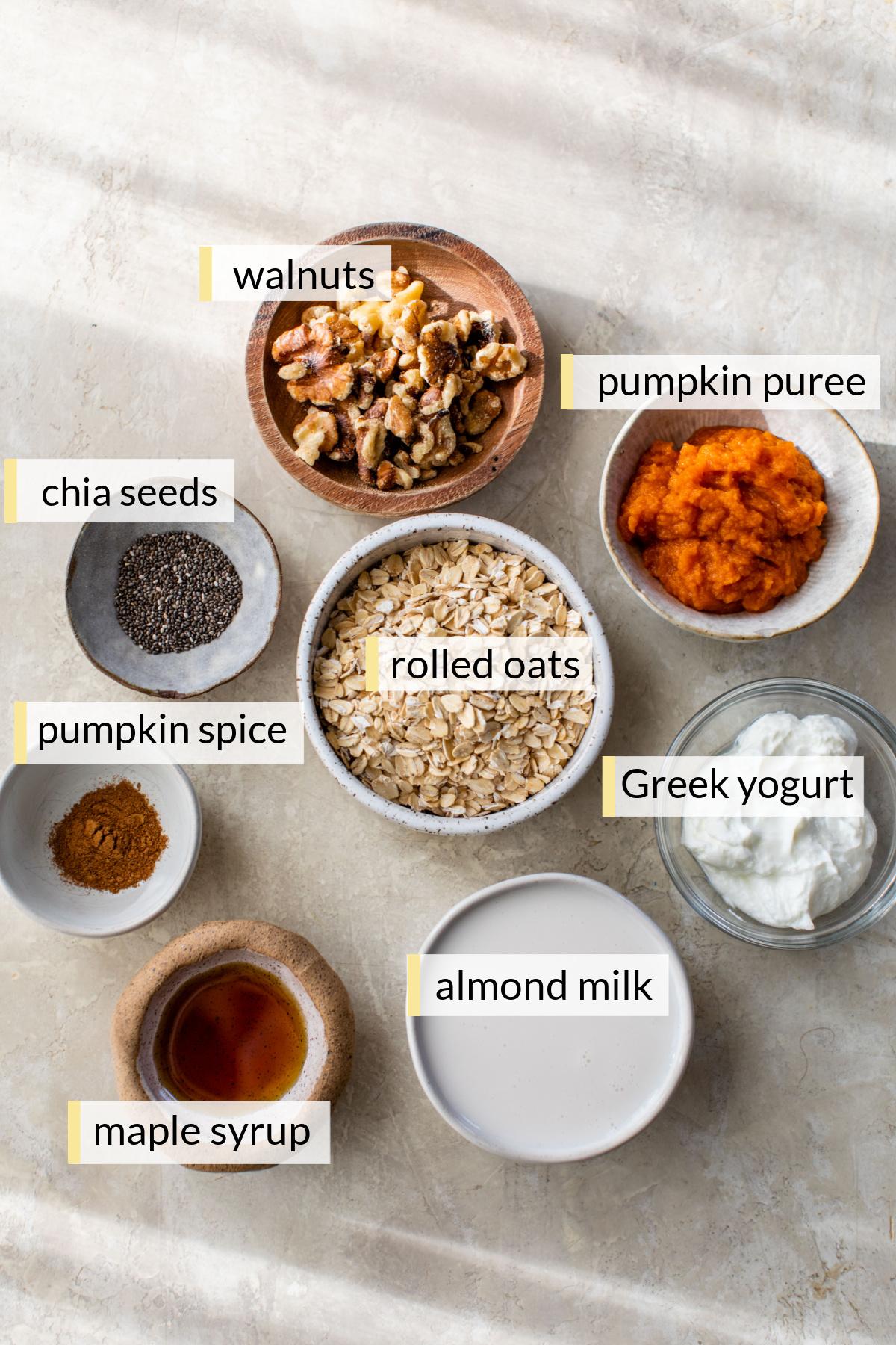Ingredients needed to make pumpkin overnight oats divided into small portions.