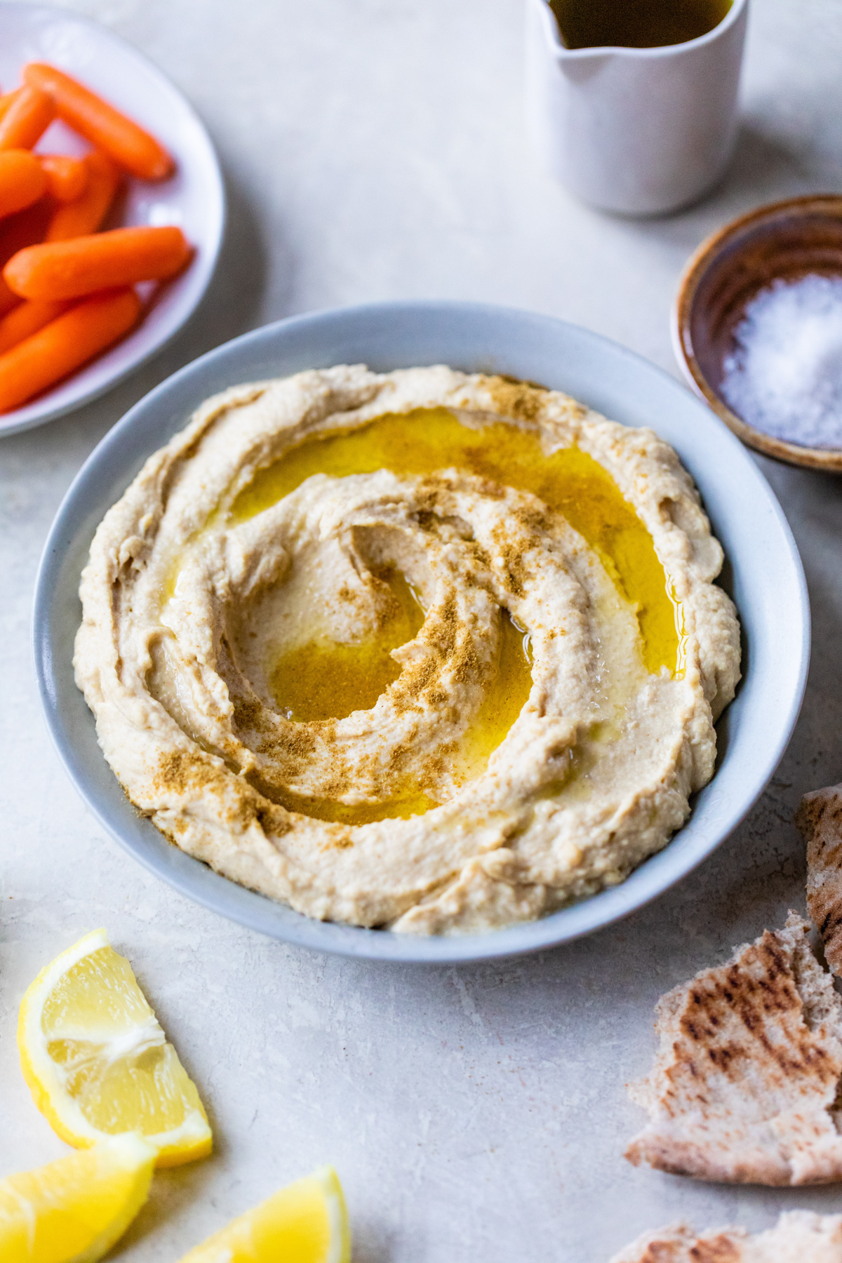 5 minute hummus with tahini and fresh garlic in a bow topped with olive oil and ground cumin