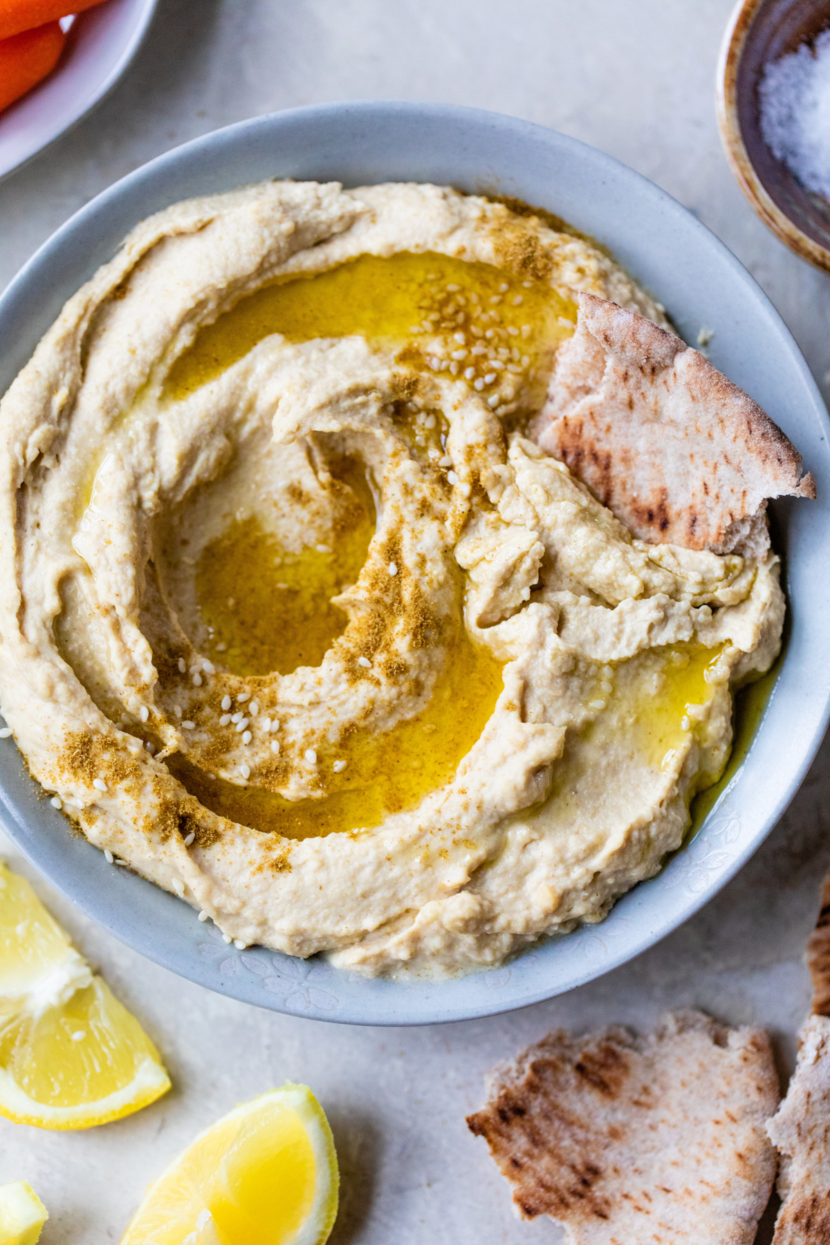 rich and creamy hummus in a small bowl topped with a drizzle of extra virgin olive oil