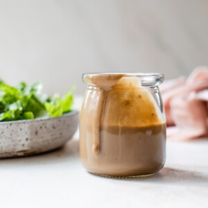 creamy balsamic dressing in a glass jar with salad greens