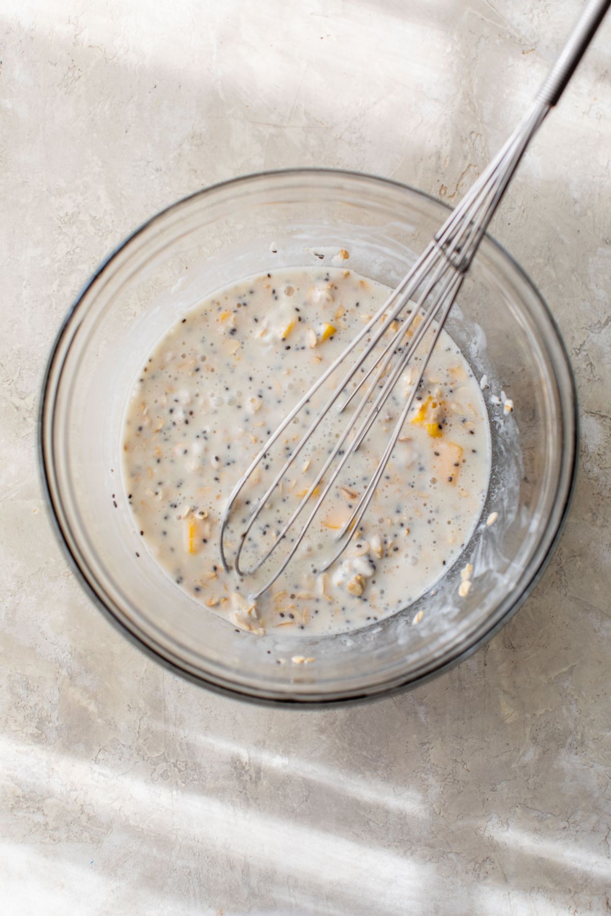 Whisking oats, greek yogurt, milk and mango in a large bowl.