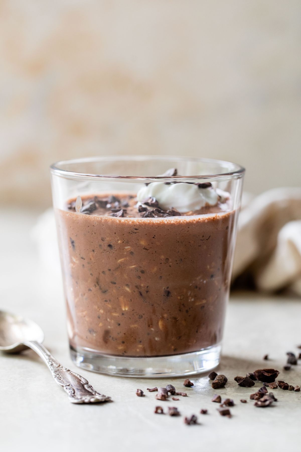 Overnight oats with cocoa powder and greek yogurt in a small glass.