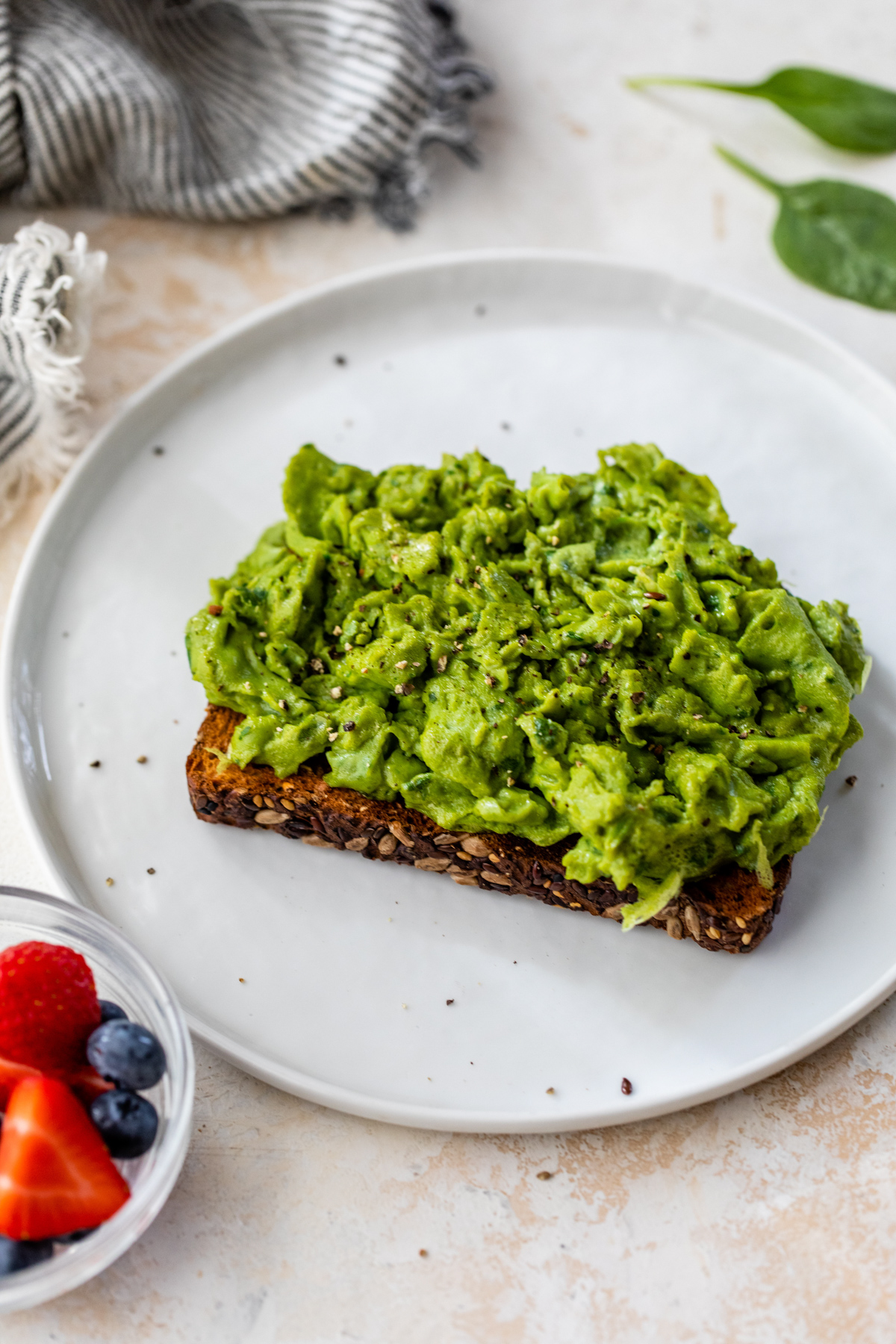 green scrambled eggs made with spinach on top of whole grain toast