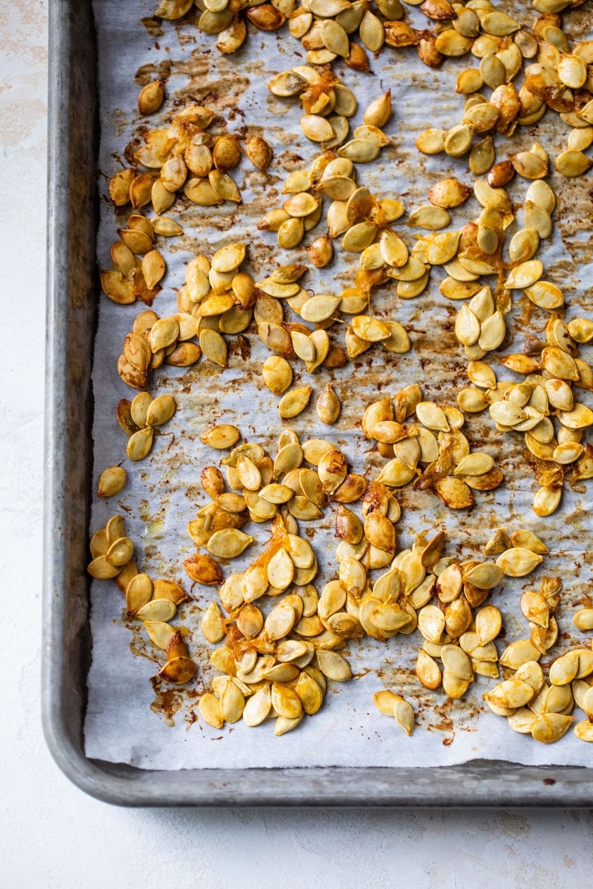 Roasted acorn squash seeds on a pan.