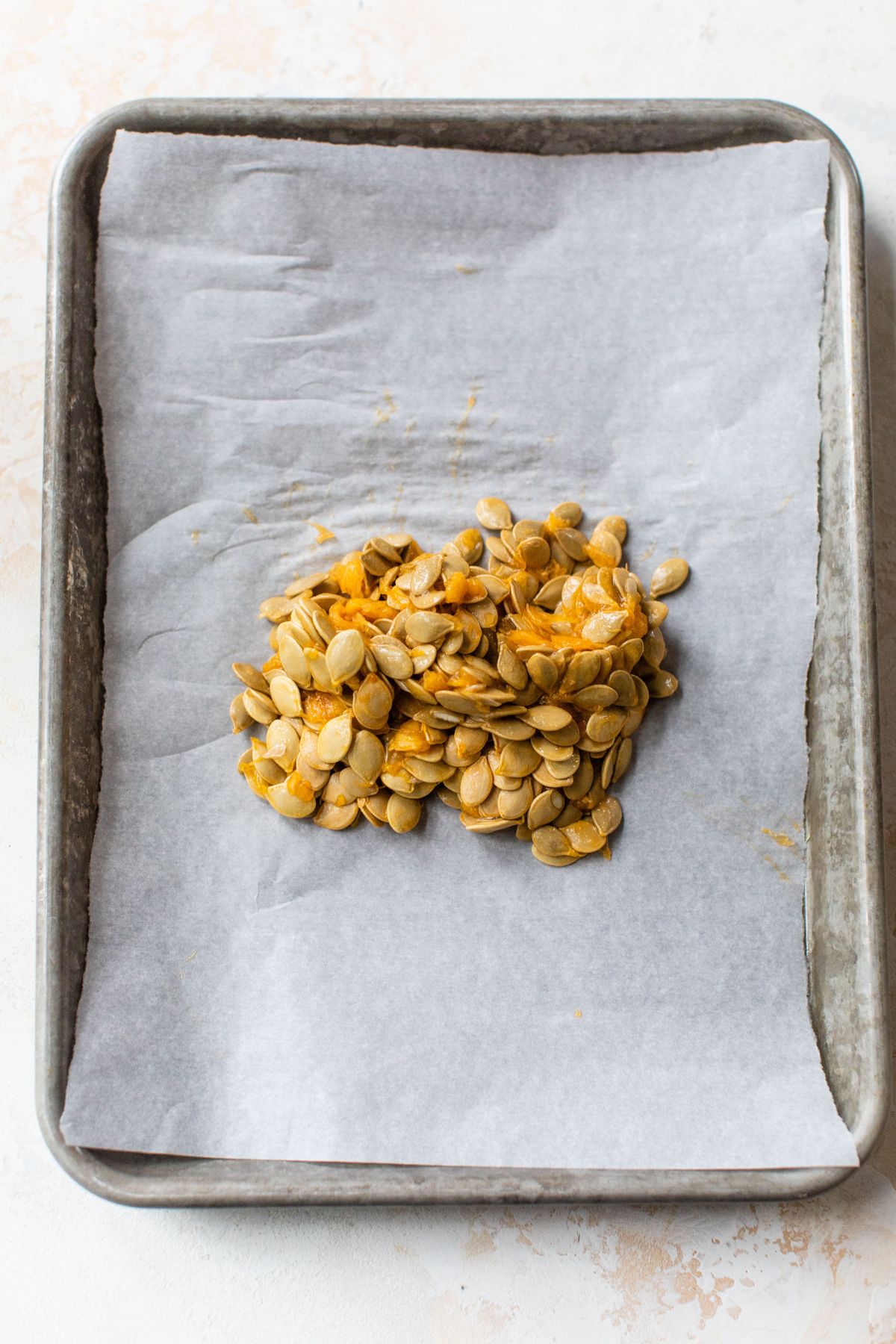 Transferring acorn squash seeds to a pan.