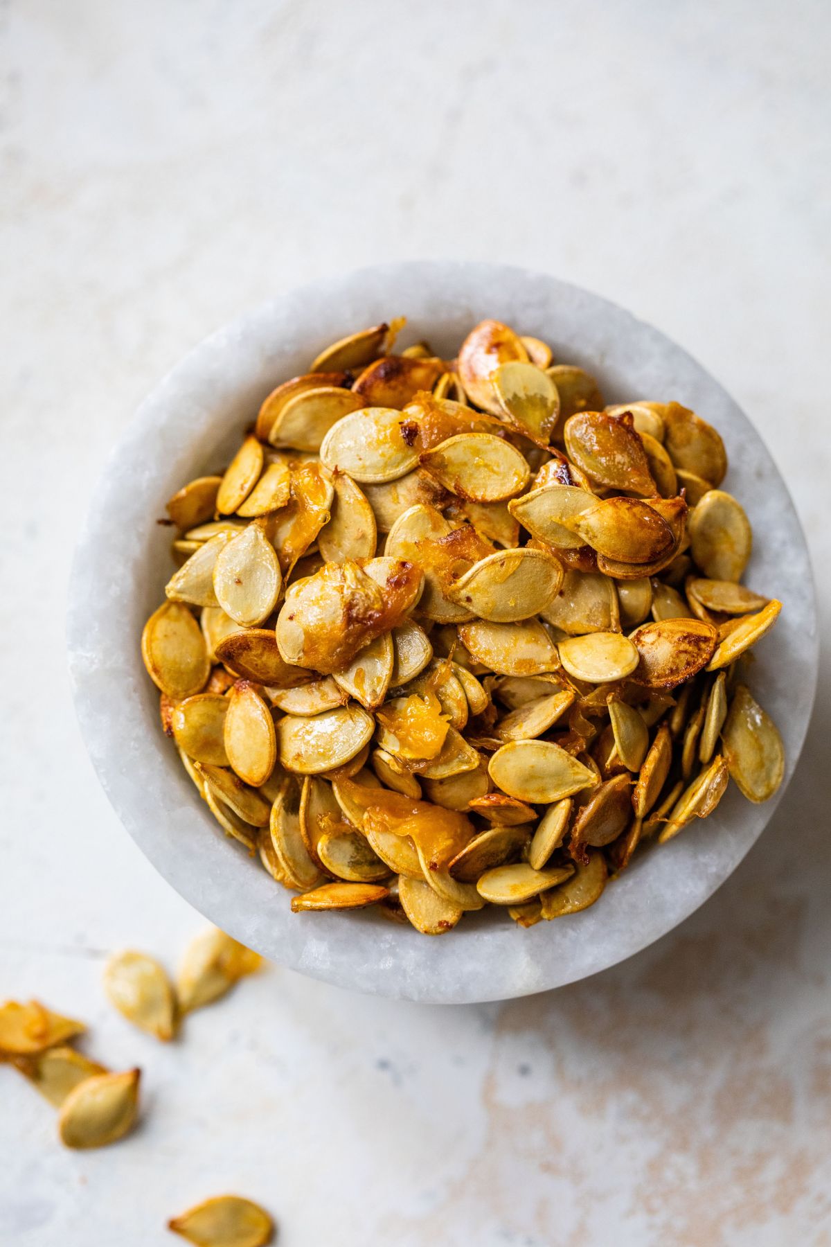 Roasted acorn squash seeds in a small marble bowl.