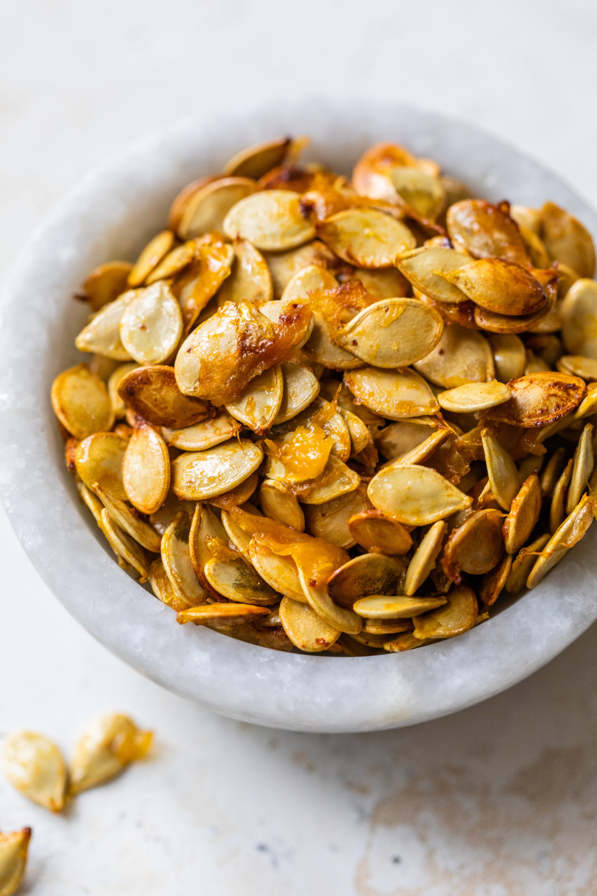 roasted and salted acorn squash seeds in a small white bowl