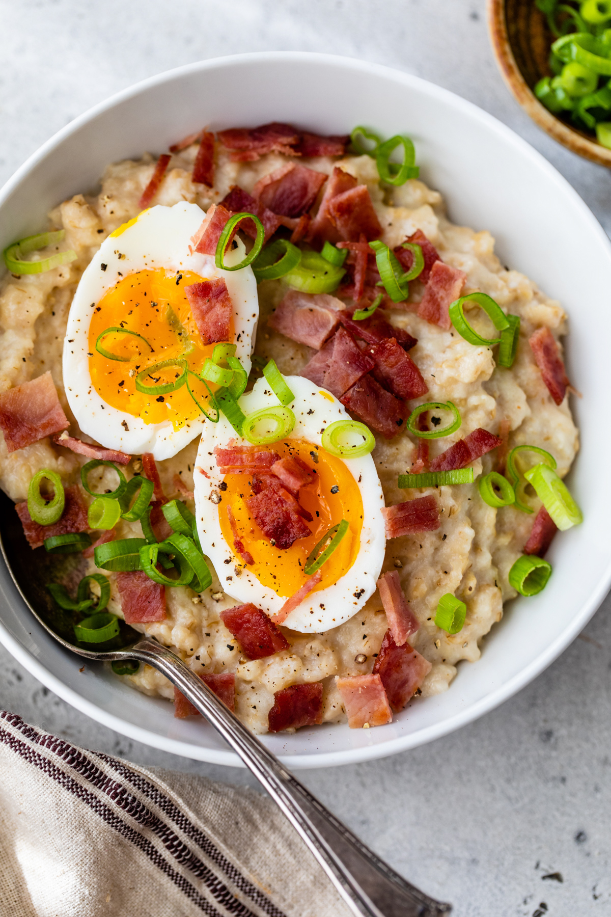 Savory Breakfast Oatmeal Topped with hard boiled eggs and turkey bacon