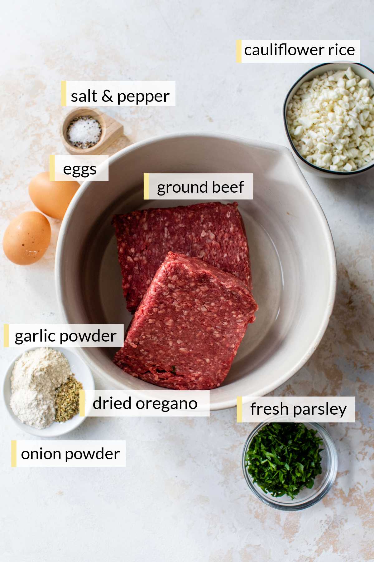 Ground beef, eggs, cauliflower rice, parsley and seasonings divided into portions.