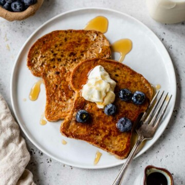 French toast on a plate topped with Greek yogurt and blueberries.