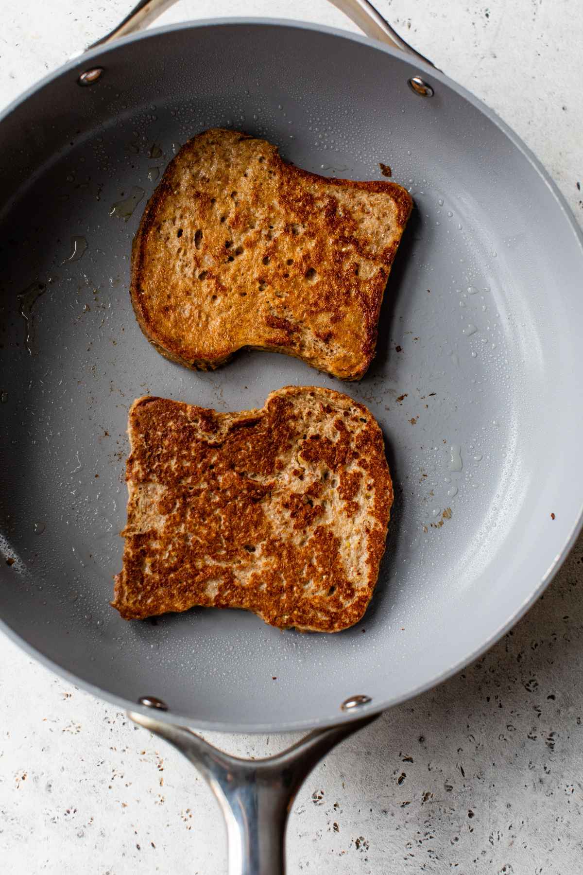 French toast bread slices cooking in a skillet.