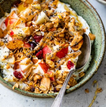 Yogurt with granola, apple and topped with honey and chia seeds.