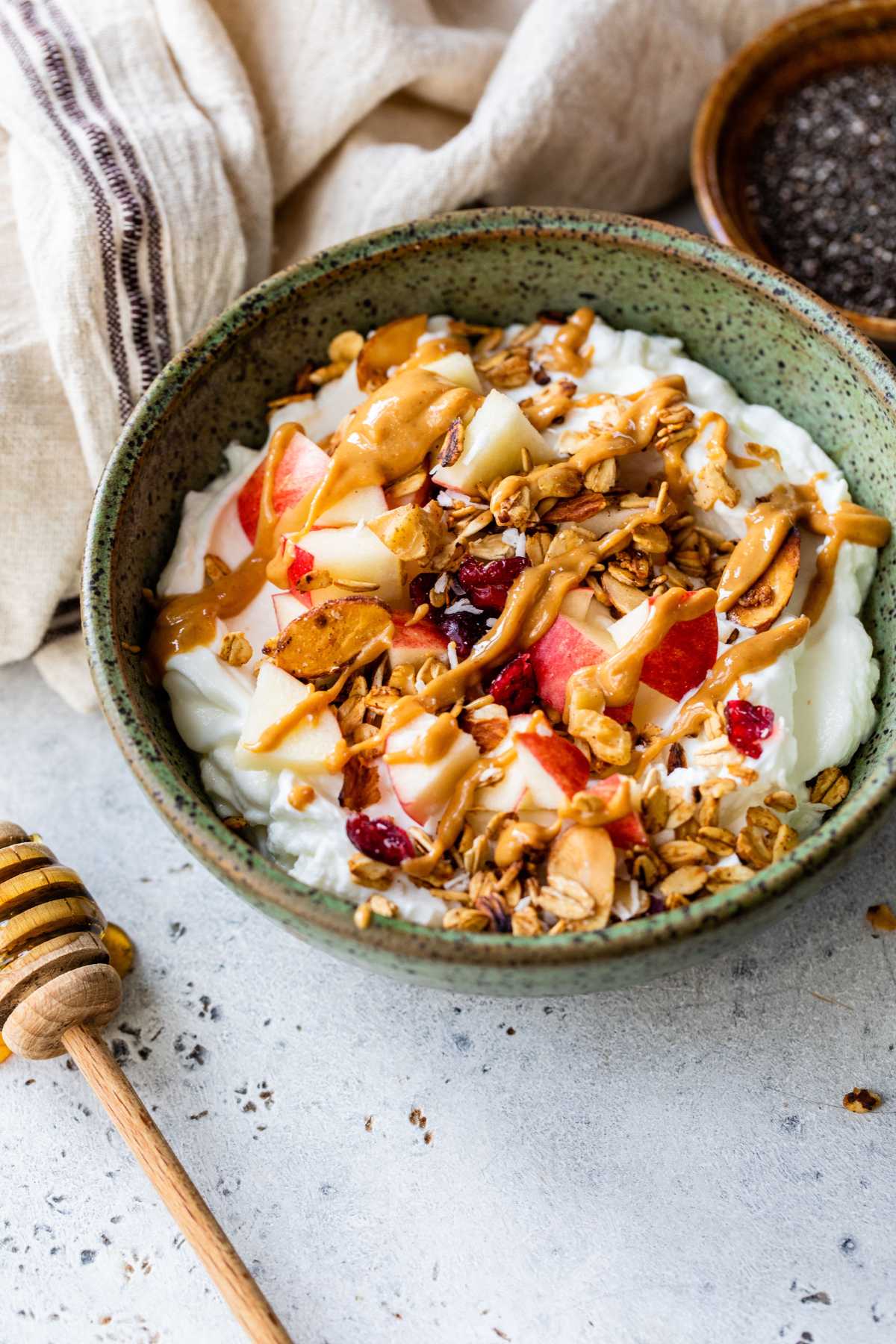 Yogurt topped with chopped apple, granola, peanut butter and honey.